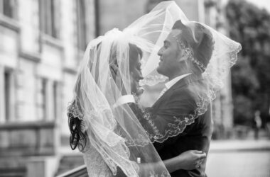 Der Hochzeitsfotograf in Hannover, Michael Siebert, setzt Brautpaar unter Schleier, schwarz weiß in Szene.